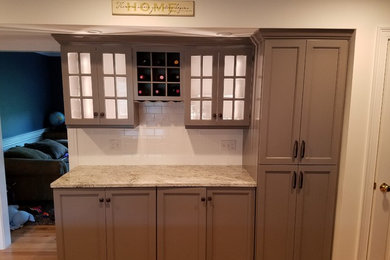 Example of a mid-sized transitional galley light wood floor and brown floor eat-in kitchen design in Other with a farmhouse sink, recessed-panel cabinets, gray cabinets, wood countertops, white backsplash, subway tile backsplash, stainless steel appliances and an island