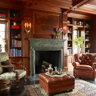 Ejemplo de despacho clásico, extra grande, con suelo de madera oscura, paredes marrones, chimenea tradicional, marco de chimenea de piedra y suelo marrón