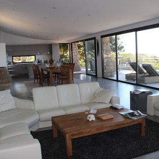 コルシカの中サイズのビーチスタイルのLDKの画像 (白い壁、コンクリートの床)