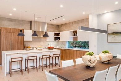 Large contemporary l-shaped eat-in kitchen in Los Angeles with an undermount sink, flat-panel cabinets, medium wood cabinets, quartzite benchtops, window splashback, panelled appliances, light hardwood floors and with island.