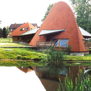 Exempel på ett eklektiskt oranget hus, med allt i ett plan och tak i shingel