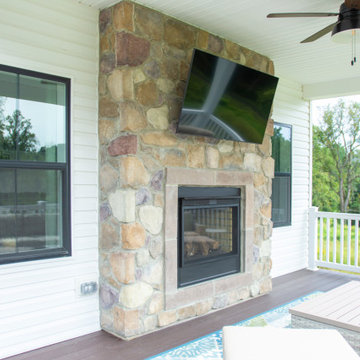 Black windows flank the outdoor television and fire place