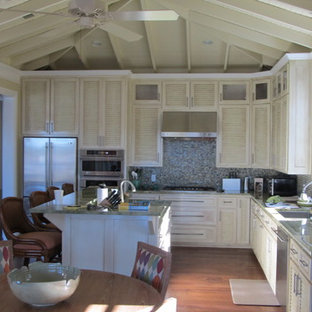 Aménagement d'une arrière-cuisine campagne en L de taille moyenne avec un évier encastré, un placard à porte persienne, des portes de placard en bois vieilli, un plan de travail en granite, une crédence multicolore, une crédence en mosaïque, un électroménager en acier inoxydable, un sol en bois brun et un îlot central.