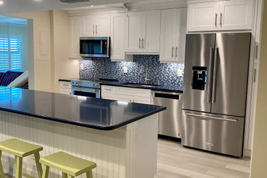 Inspiration for a mid-sized modern l-shaped vinyl floor and brown floor kitchen pantry remodel in Other with shaker cabinets, white cabinets, an island, quartz countertops, blue countertops, an undermount sink, blue backsplash, matchstick tile backsplash and stainless steel appliances