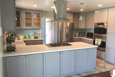 Inspiration for a mid-sized contemporary l-shaped eat-in kitchen in Los Angeles with a farmhouse sink, shaker cabinets, grey cabinets, quartzite benchtops, green splashback, glass sheet splashback, stainless steel appliances, ceramic floors and with island.