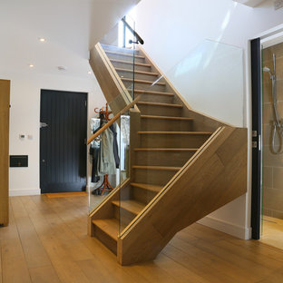 Photo of a medium sized contemporary wood curved staircase in London with wood risers.