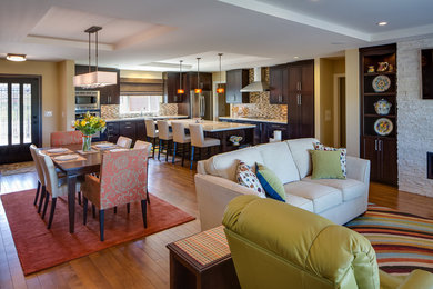 Mid-sized trendy l-shaped medium tone wood floor and brown floor open concept kitchen photo in San Diego with an undermount sink, recessed-panel cabinets, dark wood cabinets, brown backsplash, mosaic tile backsplash, stainless steel appliances, an island, solid surface countertops and beige countertops