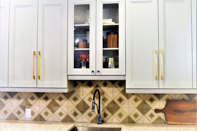 Large transitional u-shaped medium tone wood floor enclosed kitchen photo in Toronto with an undermount sink, shaker cabinets, gray cabinets, quartz countertops, multicolored backsplash and an island