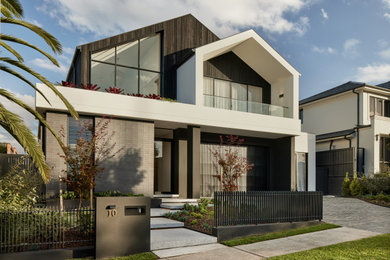 Photo of a large contemporary two-storey black house exterior with a gable roof and a black roof.