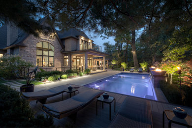 Design ideas for a transitional backyard stone waterfall in Toronto.