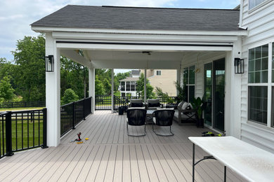 This is an example of a screened-in and metal railing porch design in DC Metro with decking.