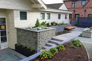 Photo of a farmhouse partial sun front yard stone and wood fence landscaping in Seattle for spring.