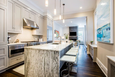 Example of a large trendy galley dark wood floor and brown floor open concept kitchen design in Richmond with an undermount sink, recessed-panel cabinets, beige cabinets, granite countertops, white backsplash, subway tile backsplash, stainless steel appliances, an island and gray countertops