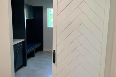 Example of a mid-sized trendy galley porcelain tile and gray floor utility room design in Phoenix with an undermount sink, shaker cabinets, black cabinets, gray walls, a side-by-side washer/dryer and white countertops