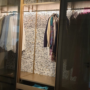 Cette photo montre un dressing room moderne de taille moyenne et neutre avec un placard à porte vitrée, des portes de placard marrons, un sol en brique et un sol marron.