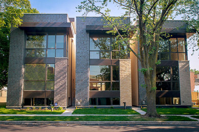 Example of a minimalist beige two-story brick flat roof design in Chicago