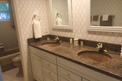 Mid-sized traditional kids bathroom in Tampa with raised-panel cabinets, white cabinets, beige tile, ceramic tile, multi-coloured walls, ceramic floors and granite benchtops.