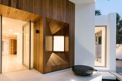 Modern entryway in Perth with white walls, granite floors, a pivot front door and a light wood front door.