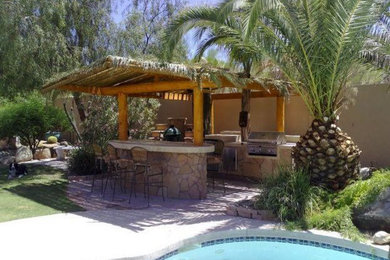 Example of an island style patio kitchen design in Tampa