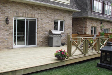 Example of a mid-sized classic backyard deck design in Toronto with no cover