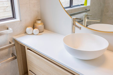 Small minimalist master white tile and porcelain tile porcelain tile, white floor and single-sink bathroom photo in Auckland with light wood cabinets, white walls, a vessel sink, solid surface countertops, white countertops, a niche and a floating vanity