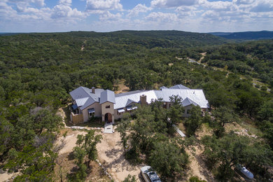 Inspiration for a huge mediterranean white two-story stucco exterior home remodel in Austin with a metal roof