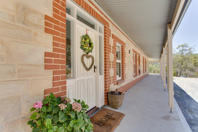 This is an example of a large traditional one-storey exterior in Adelaide with stone veneer.