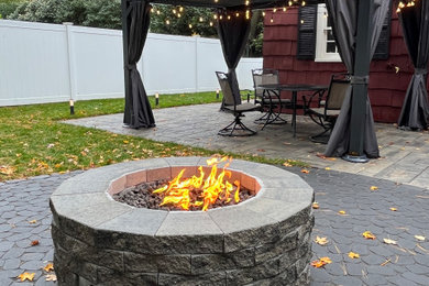 Inspiration for a contemporary backyard patio remodel in Newark with a fire pit
