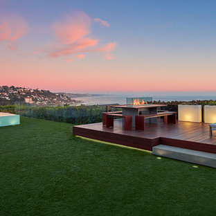 ロサンゼルスの中サイズのミッドセンチュリースタイルのおしゃれな裏庭のデッキ (日よけなし、ファイヤーピット) の写真