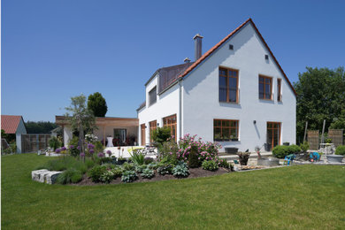 Geometrischer, Großer Country Garten im Sommer, neben dem Haus mit Blumenbeet, direkter Sonneneinstrahlung und Natursteinplatten in München