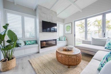 Inspiration for a mid-sized beach style open concept living room in Gold Coast - Tweed with white walls, painted wood floors, a standard fireplace, a stone fireplace surround and grey floor.