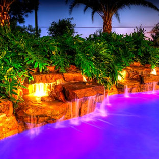 Ispirazione per una grande piscina monocorsia mediterranea personalizzata dietro casa con una vasca idromassaggio e pavimentazioni in pietra naturale