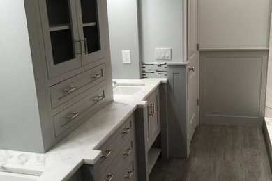Design ideas for a mid-sized transitional master bathroom in Portland with an undermount sink, recessed-panel cabinets, grey cabinets, marble benchtops, a freestanding tub, a corner shower, a one-piece toilet, gray tile, grey walls and porcelain floors.