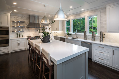 Large transitional u-shaped dark wood floor and brown floor eat-in kitchen photo in New York with an undermount sink, shaker cabinets, white cabinets, quartz countertops, white backsplash, stone tile backsplash, stainless steel appliances and an island