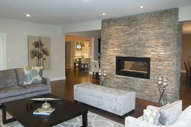 Mid-sized trendy formal and open concept dark wood floor living room photo in Vancouver with beige walls, a two-sided fireplace, a stone fireplace and no tv