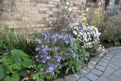 Kleiner, Halbschattiger Landhaus Garten im Innenhof im Herbst mit Blumenbeet, Pflastersteinen und Holzzaun in Hamburg