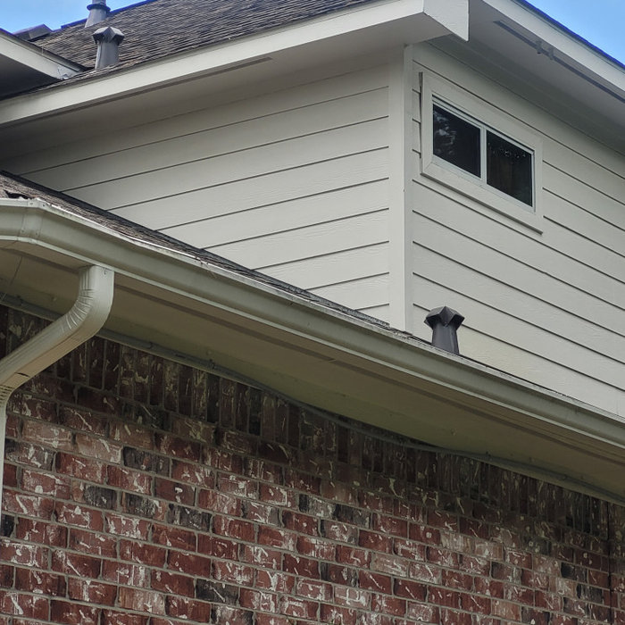 This project started with some non-Hardie fiber-cement siding planks delaminating above the roof lines.  This was caused by the builder resting the siding on the roof, we cut all the siding on the hou