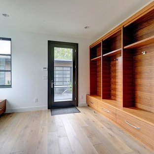 ポートランドの巨大なコンテンポラリースタイルのおしゃれな家事室 (アンダーカウンターシンク、フラットパネル扉のキャビネット、白いキャビネット、クオーツストーンカウンター、ラミネートの床、左右配置の洗濯機・乾燥機、グレーの床、グレーのキッチンカウンター、白い壁) の写真