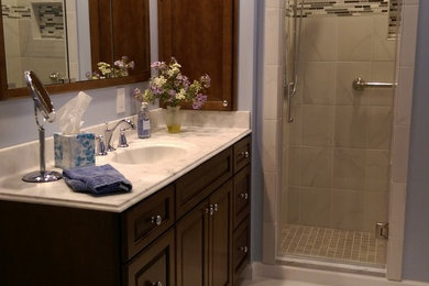 Alcove shower - mid-sized contemporary 3/4 white tile and porcelain tile porcelain tile alcove shower idea in Philadelphia with raised-panel cabinets, dark wood cabinets, a two-piece toilet, blue walls, an integrated sink and solid surface countertops