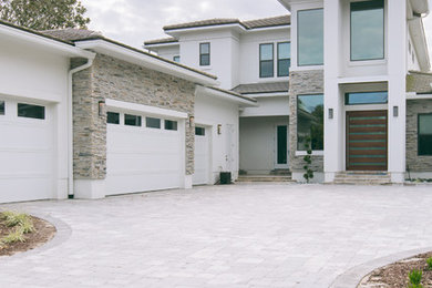 Large contemporary white two-story stucco house exterior idea in Jacksonville with a hip roof and a shingle roof