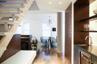 Great room - mid-sized contemporary medium tone wood floor and brown floor great room idea in New York with white walls