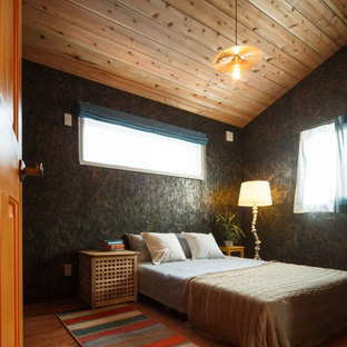 Immagine di una camera da letto etnica con pareti nere, pavimento in legno massello medio e pavimento marrone