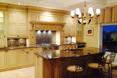 Inspiration for a large contemporary single-wall marble floor kitchen pantry remodel in Montreal with an undermount sink, glass-front cabinets, beige cabinets, granite countertops, multicolored backsplash, metal backsplash and stainless steel appliances