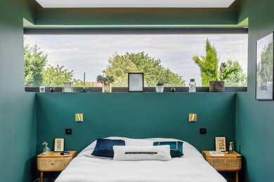 Idée de décoration pour une chambre ethnique de taille moyenne avec un mur vert, un sol gris et du papier peint.