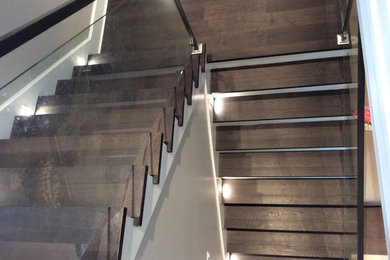 Inspiration for a large contemporary wooden u-shaped metal railing staircase remodel in Vancouver with painted risers