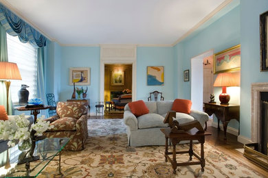 Living room - large traditional formal and enclosed medium tone wood floor living room idea in New York with blue walls, a standard fireplace, a stone fireplace and no tv