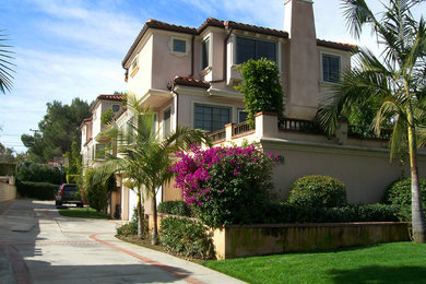 This is an example of a large mediterranean three-storey stucco beige apartment exterior in Los Angeles.