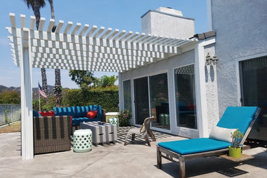 Example of a large trendy backyard brick patio design in Los Angeles with a pergola