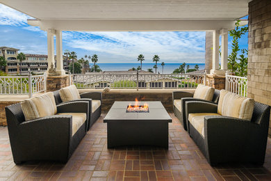 Example of a classic brick patio design in Denver with a fire pit and a pergola