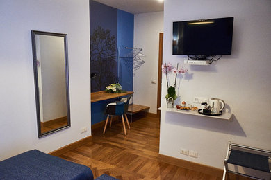 Immagine di una grande camera matrimoniale contemporanea con pareti blu e parquet chiaro